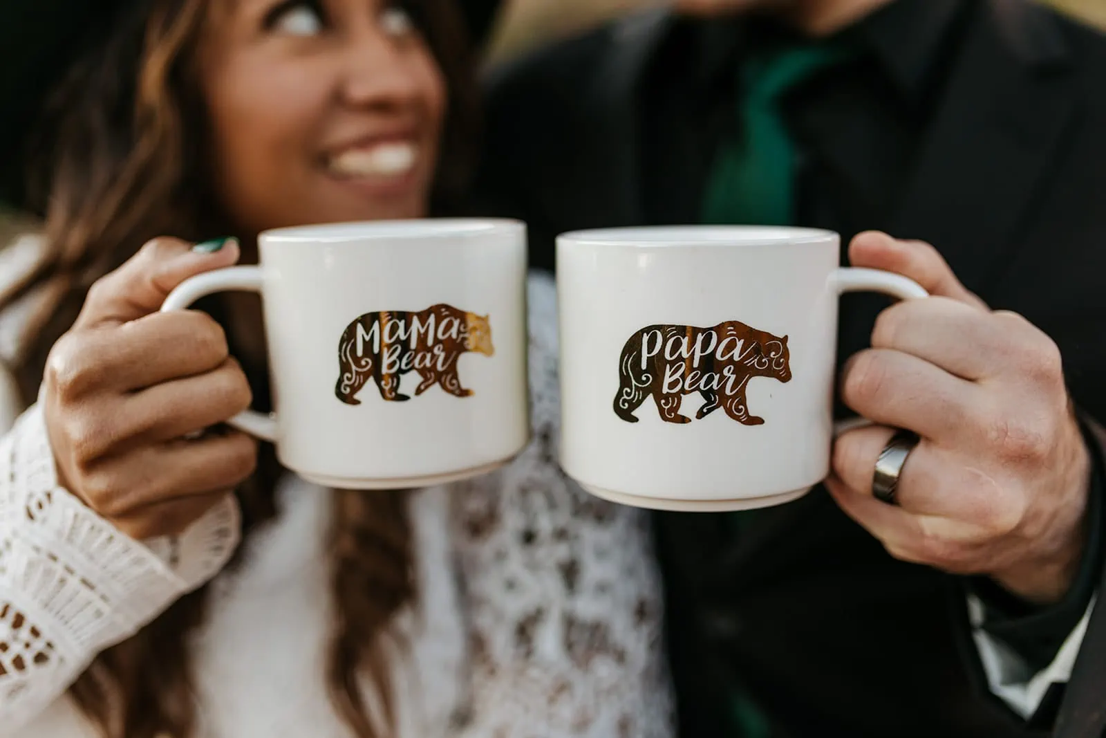 A pregnant bride and groom cheers mugs that say papa bear and mama bear