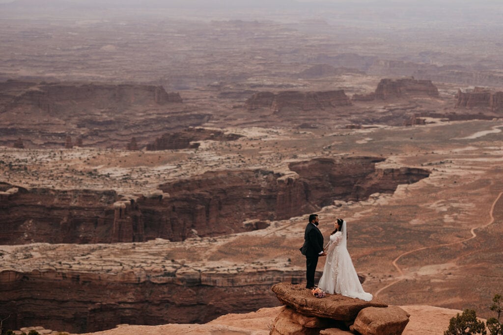 The couple stands on a beautiful vista.
