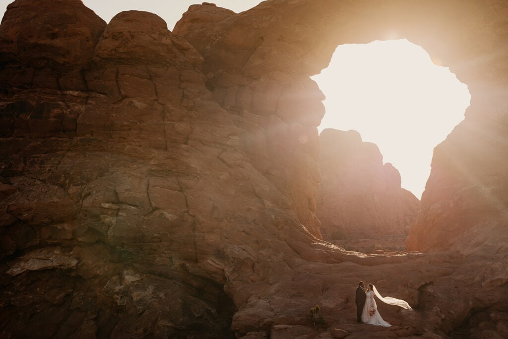 The couple poses for a portrait once the sun rises in Arches National Park.