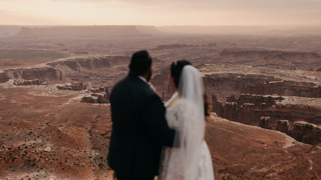 A couple looks out at canyonlands.