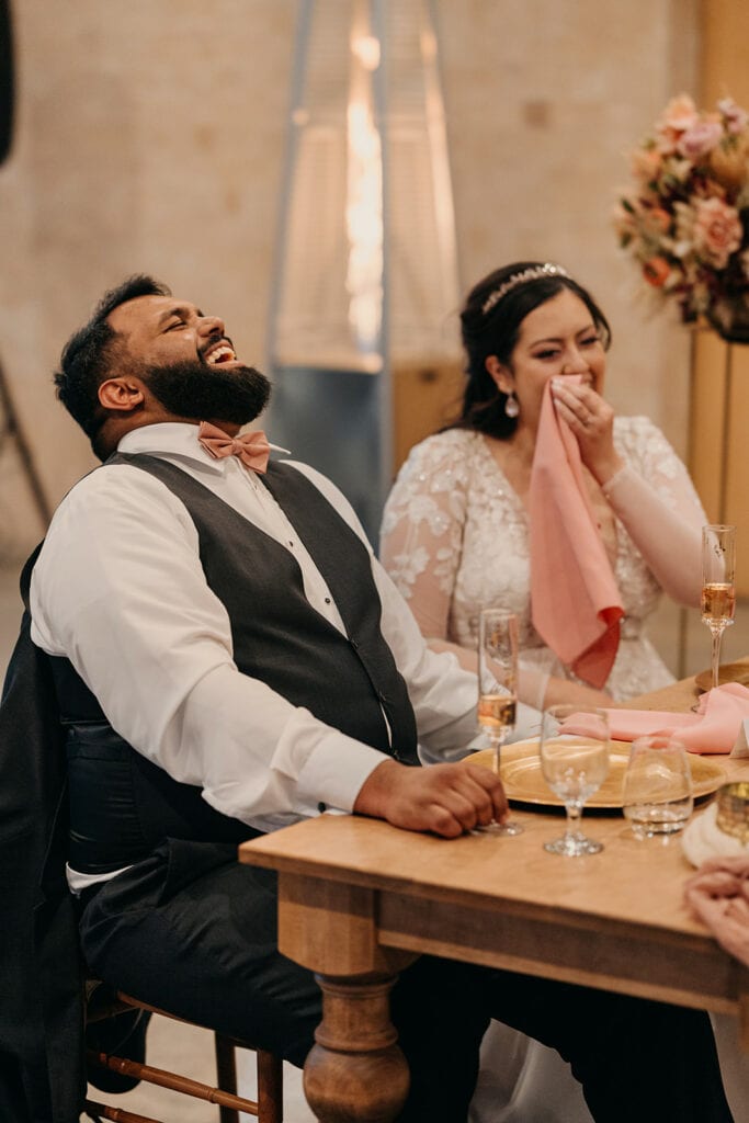 the groom laughs at one of the toasts.
