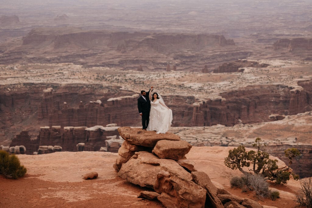 A couple shares a twirl at an Overlook after shari their vows in Canyonlands.