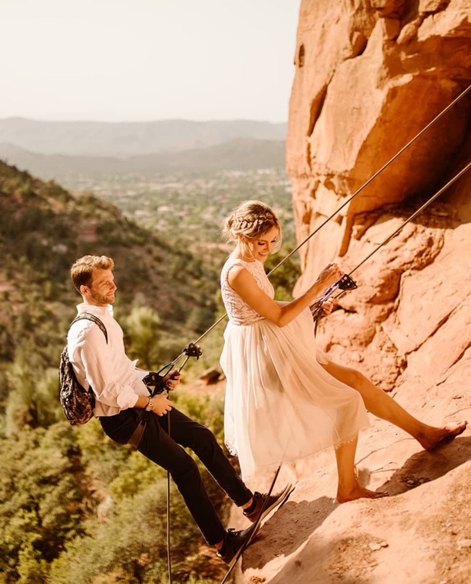 A couple rappels together out of a canyon on their elopement day in Sedona.