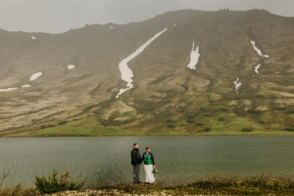 A photo of the bride and groom by the lake.