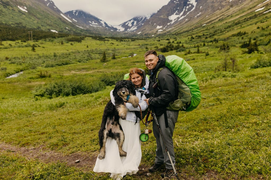 A group portrait of the couple with their dog.