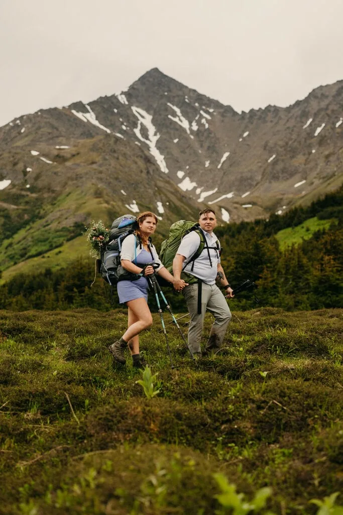 A couple holds hands while backpacking in alaska.