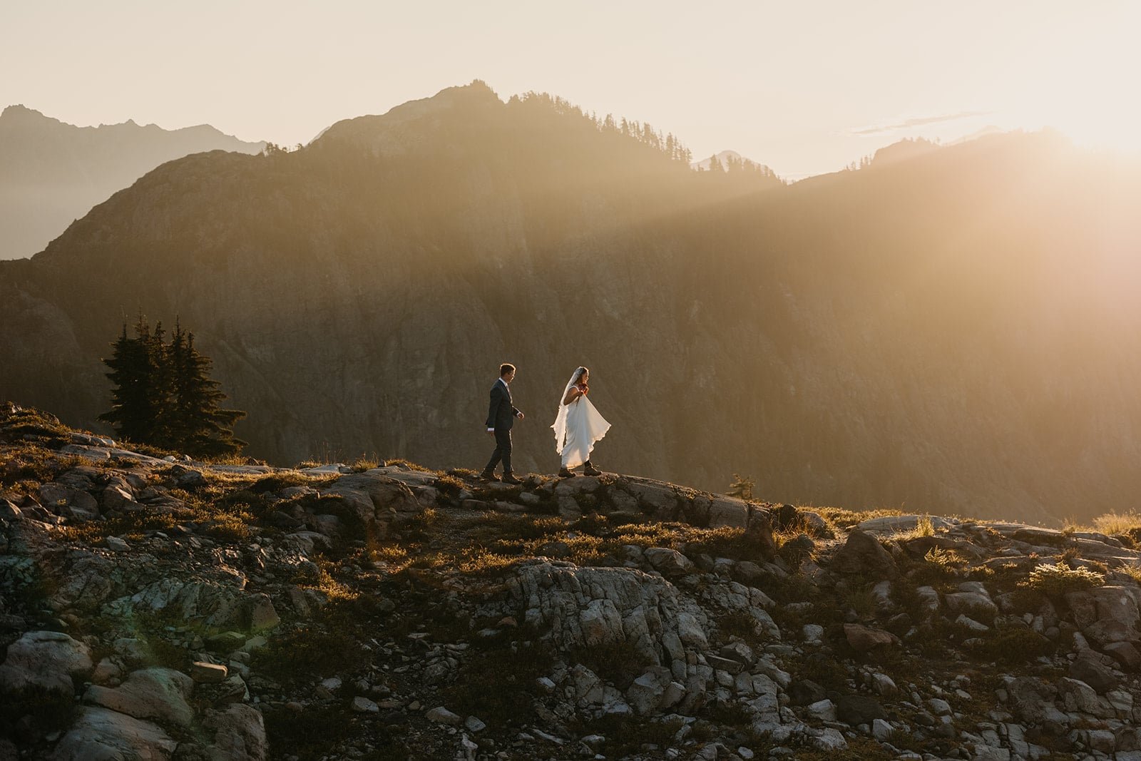 The bride and groom hike in the morning sunrise light.