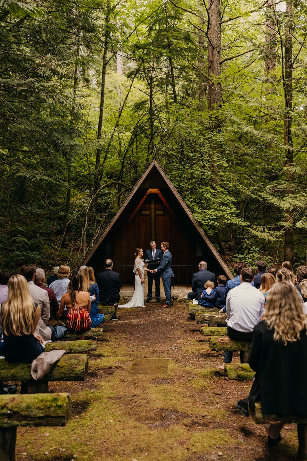 The couple during the ceremony in the mossy forest at the campground.