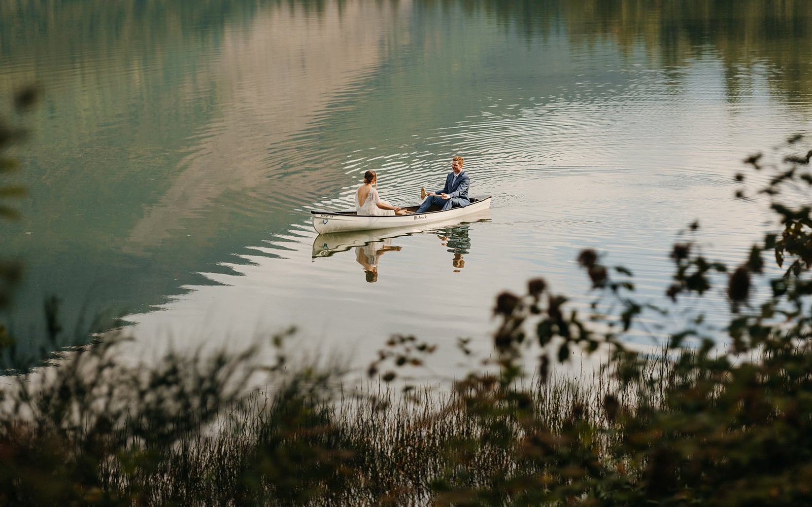 The couple canoes on the lake at camp following their wedding ceremony.