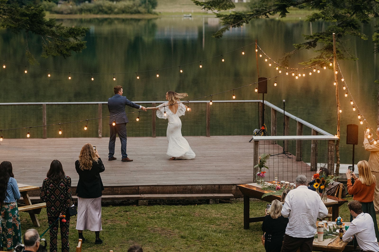 A couple shares their first dance at dusk on the deck of Camp Saturna.