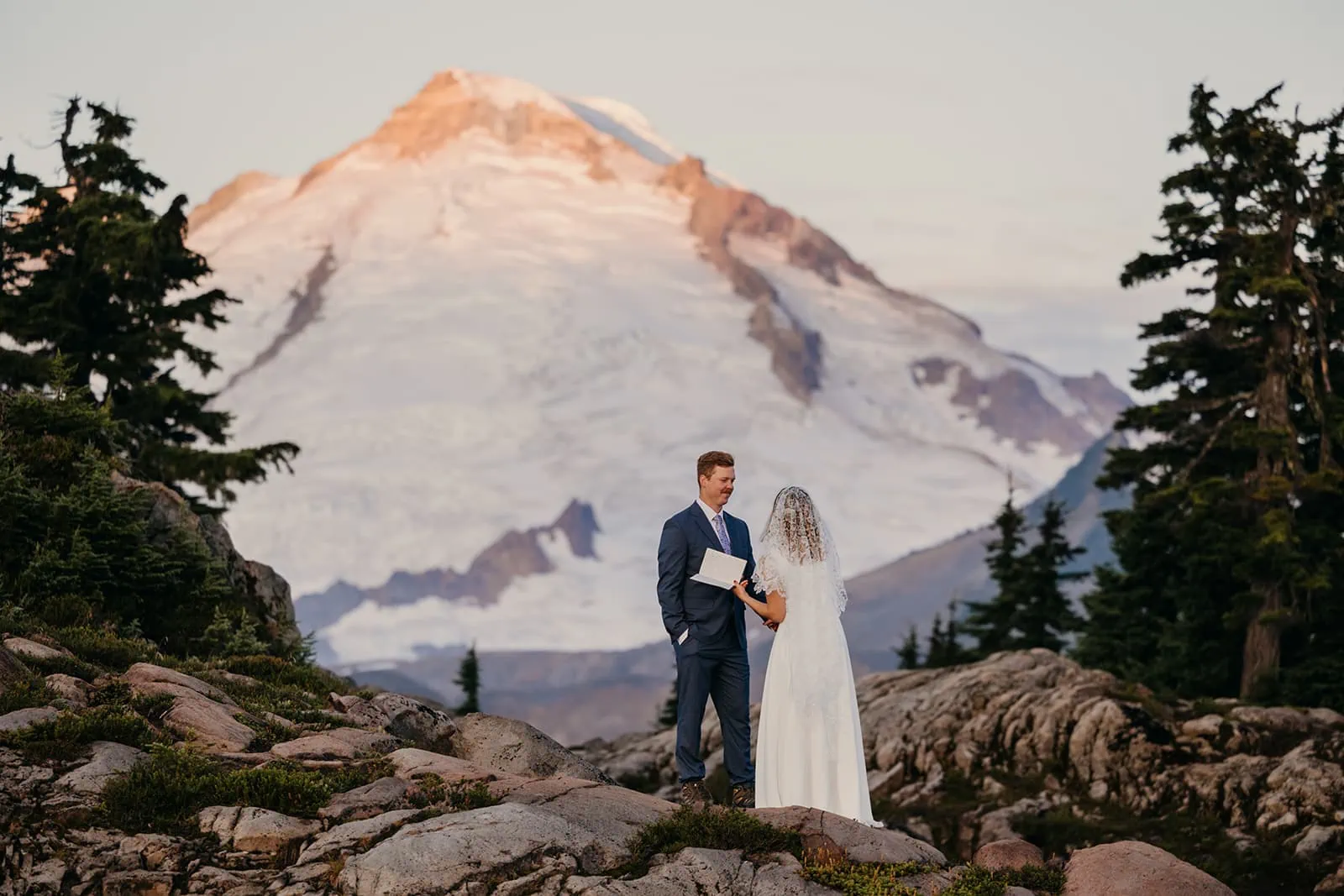 A groom reads his vows as alpine glow shines onto Mt Baker.