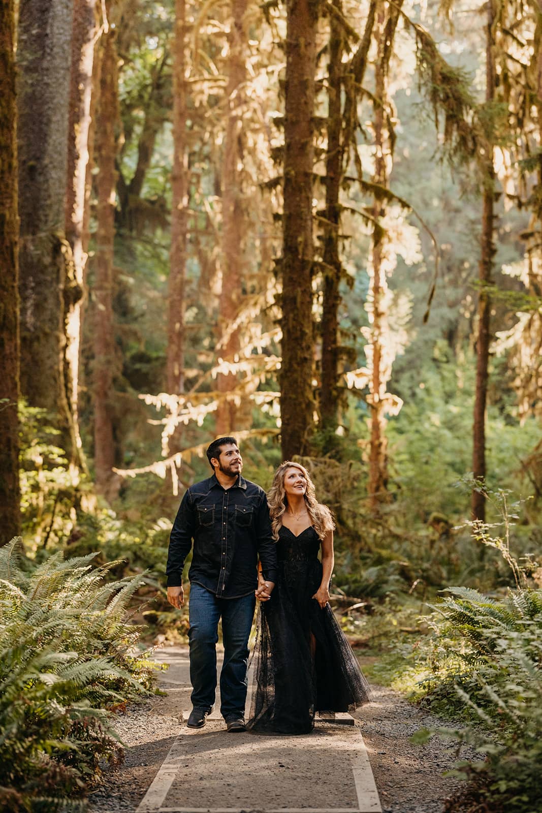 The couple walks together through the forest. 