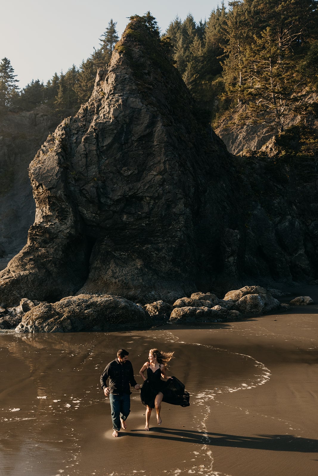 A couple runs together on the beach. 