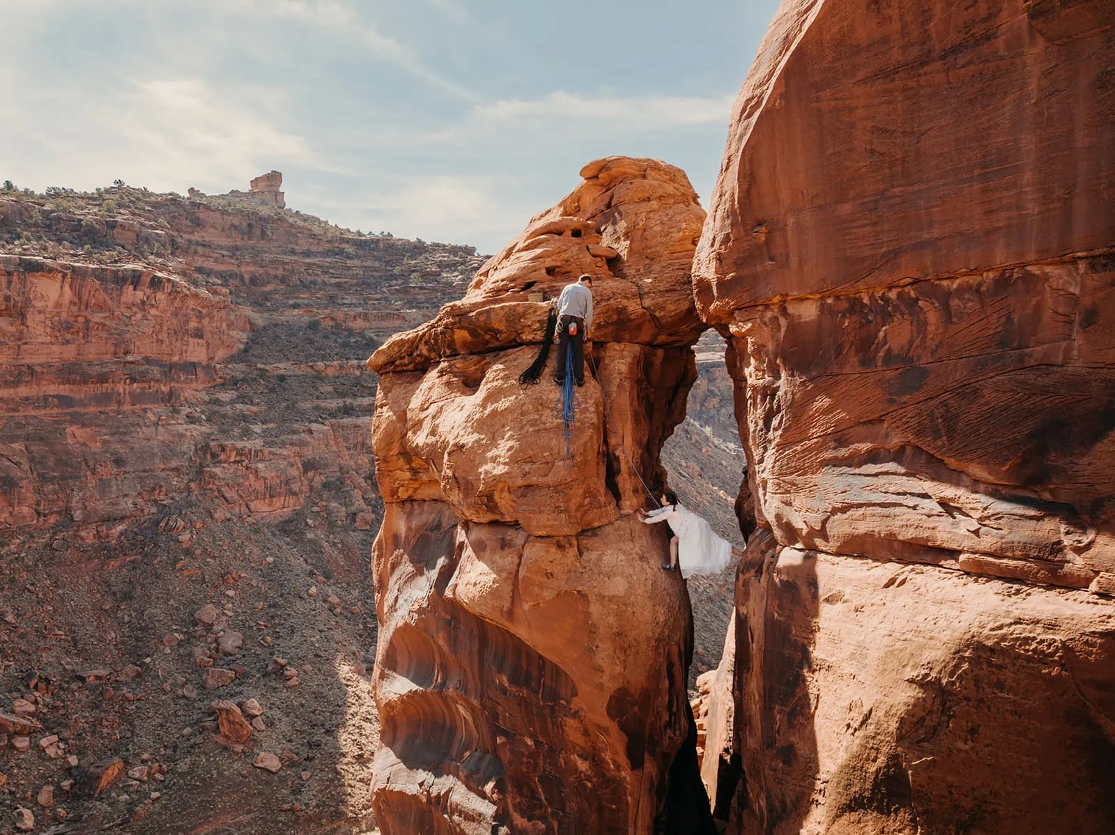 A bride stems up a trad rock climbing route.
