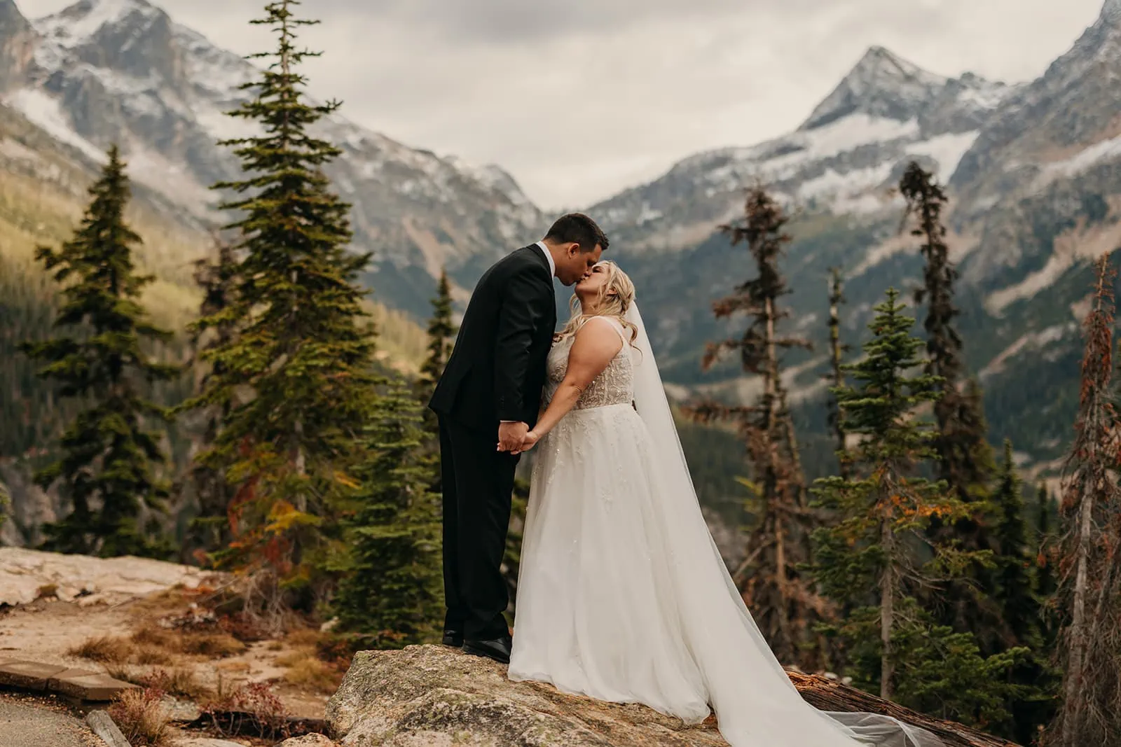 A couple shares a romantic kiss on a fall day in North Cascades National park.
