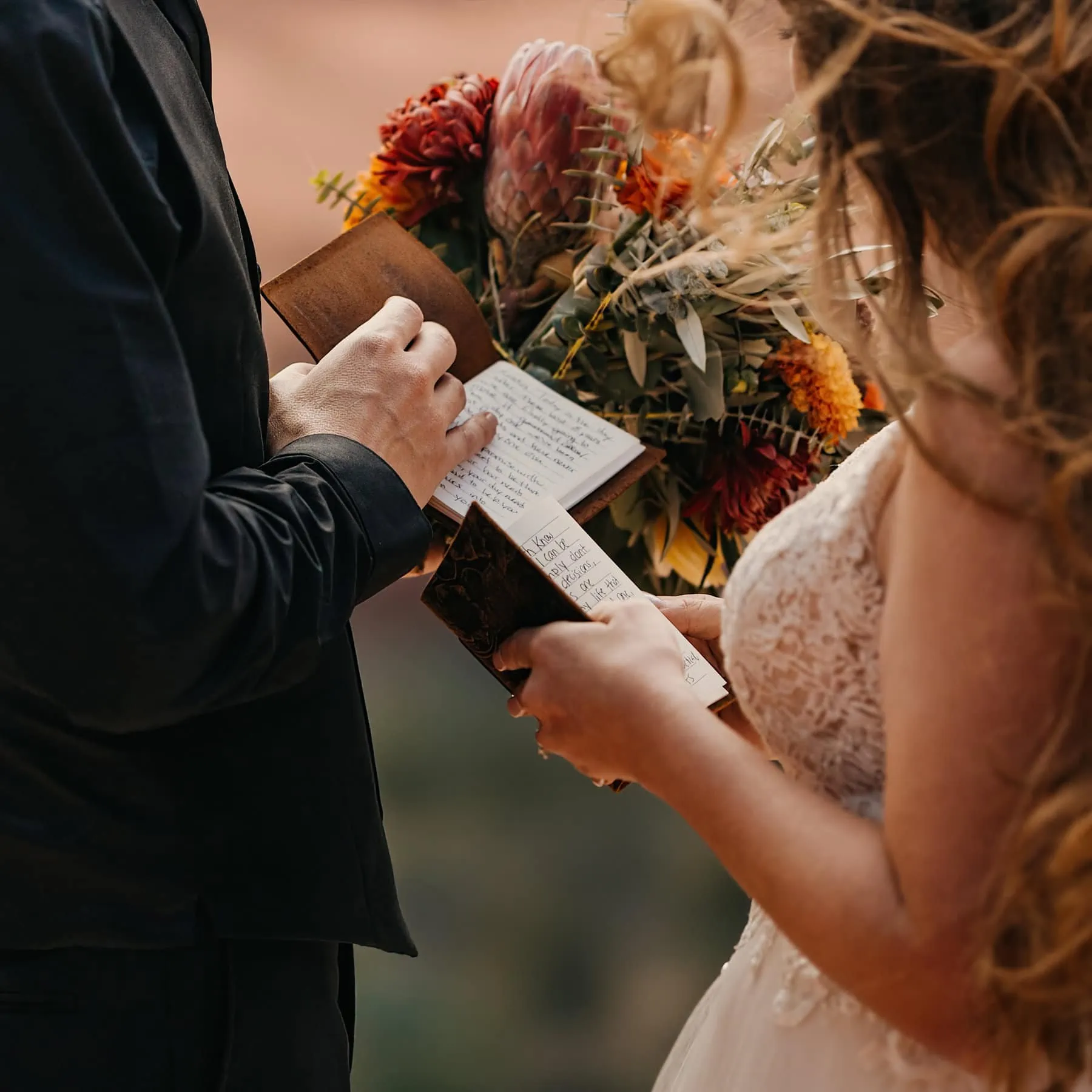 A bride and groom privately share with each other what they wrote in their vow books.