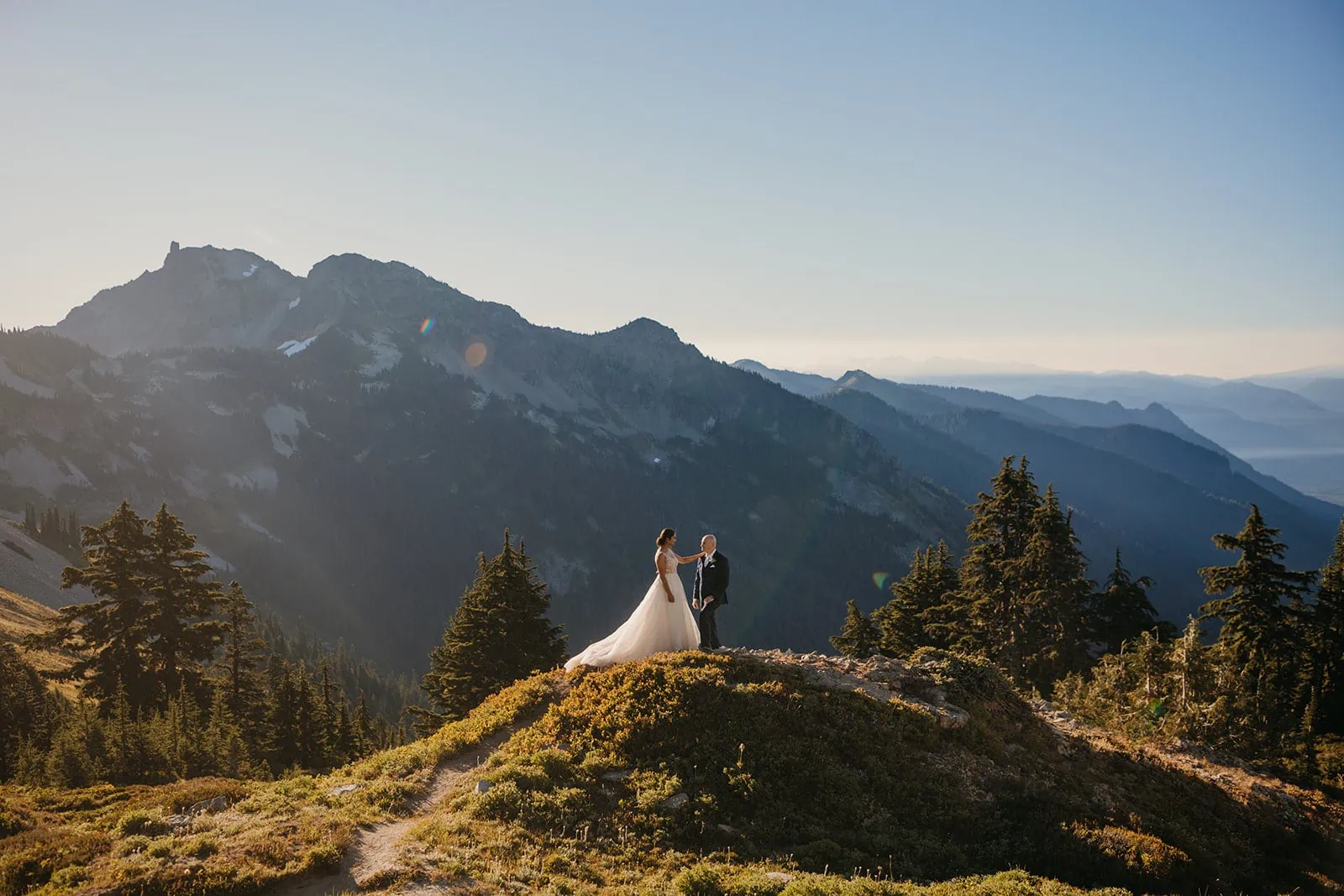 A bride and groom stand in awe of the mountains in mt Rainier
