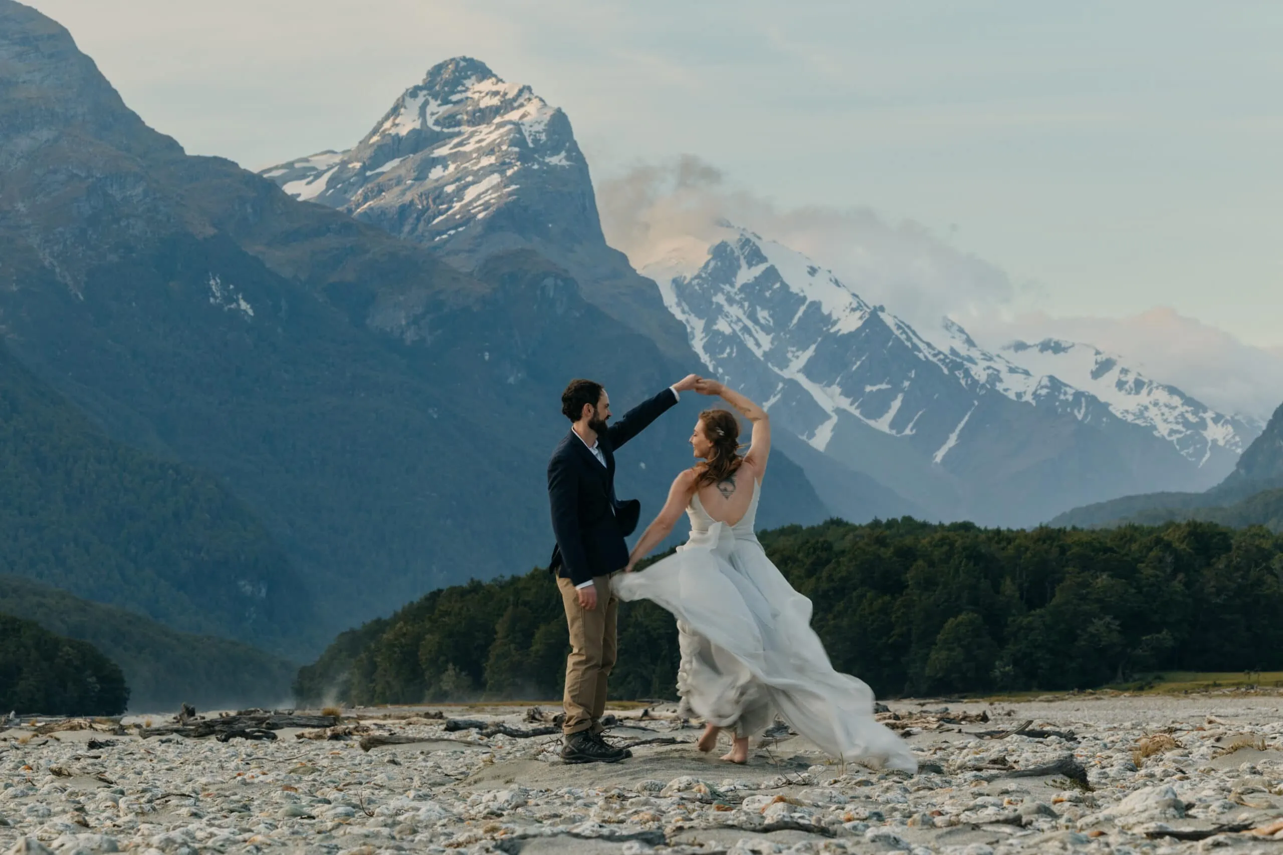A couple dances by a river in the mountains of New Zealand.