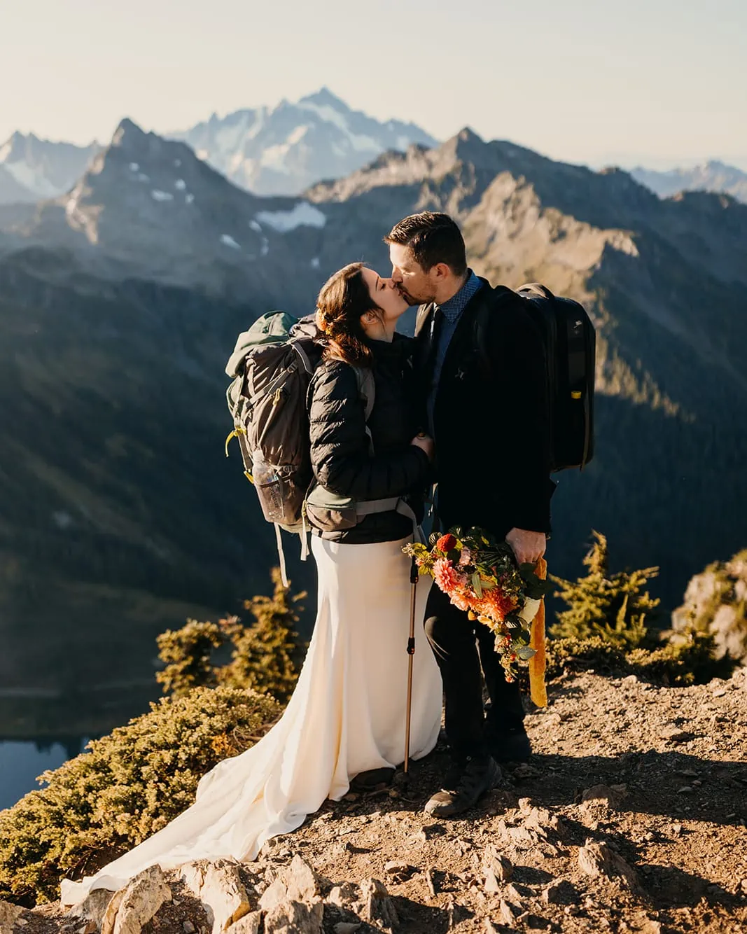 A couple shares a kiss after reaching the summit of Winchester Mountain on their elopement day.