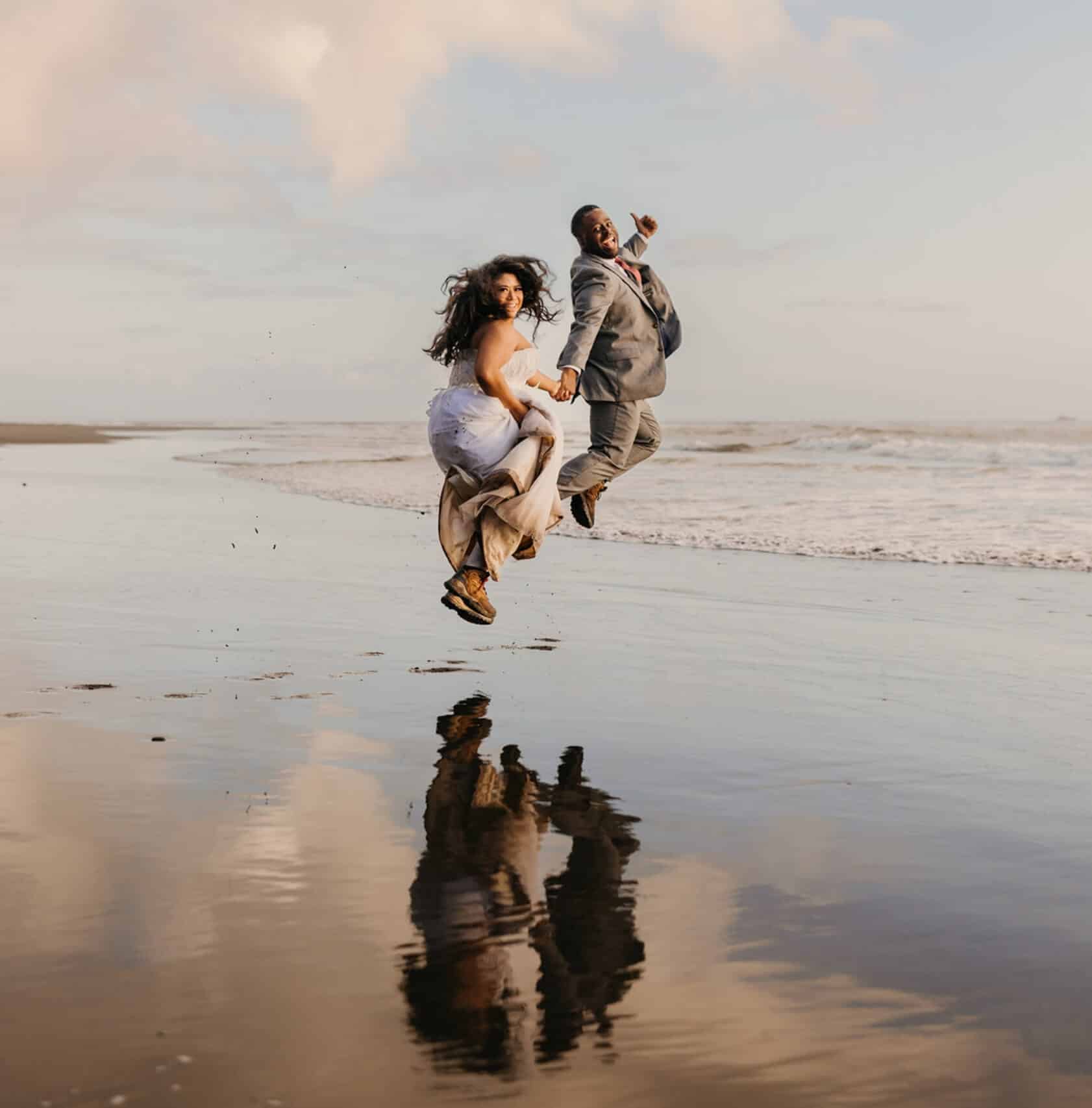 A wedding couple jumping up and smiling in the salt flats