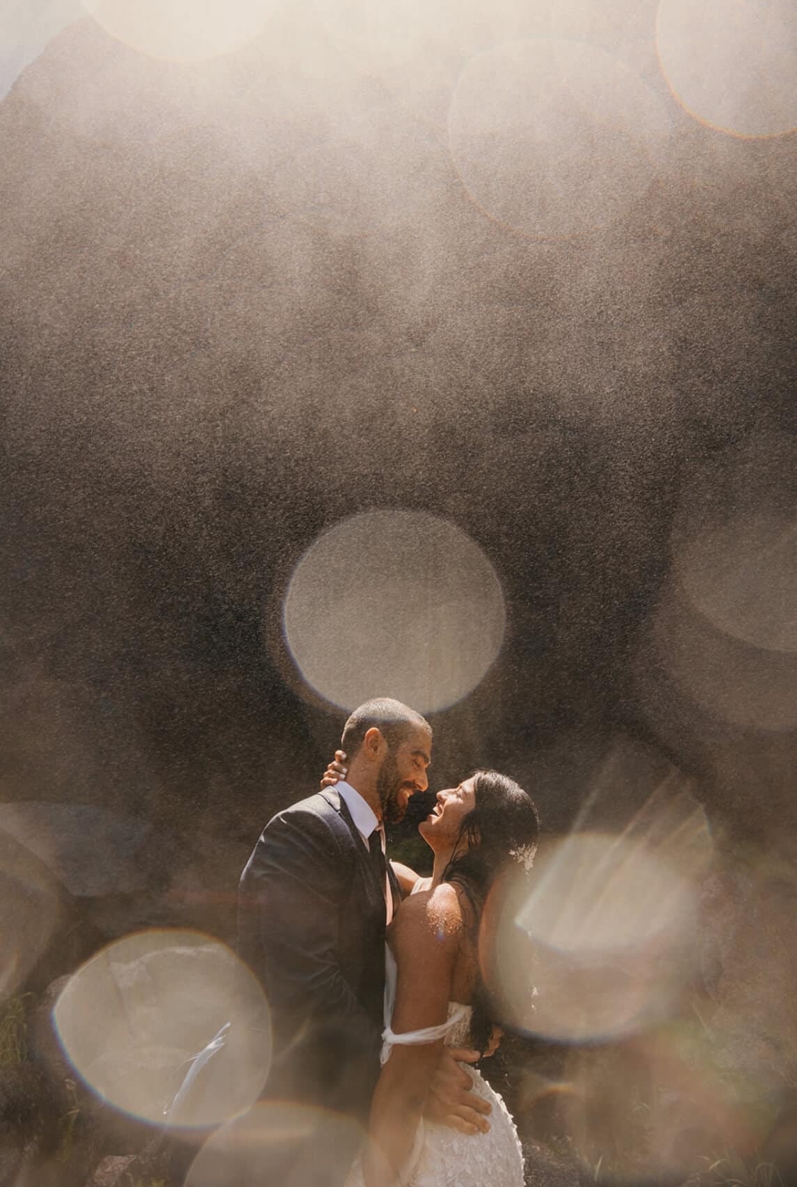 A newlywed couple standing close together about to kiss