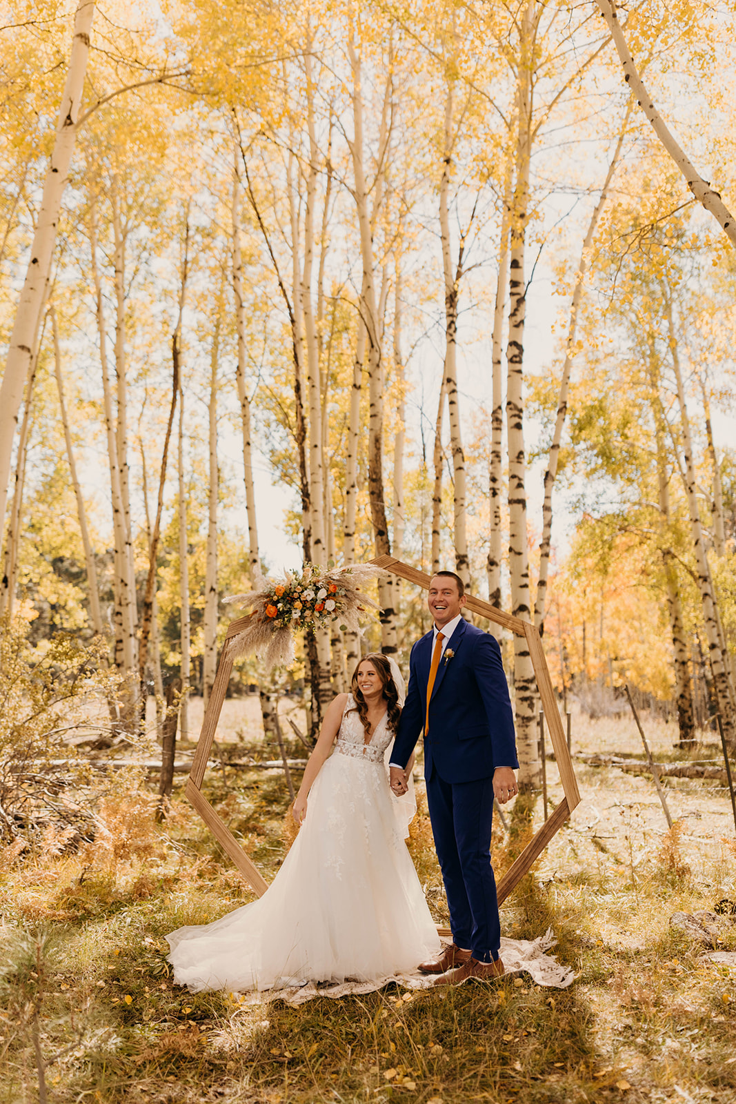 A couple smiles with joy after saying I do under the fall aspens. 