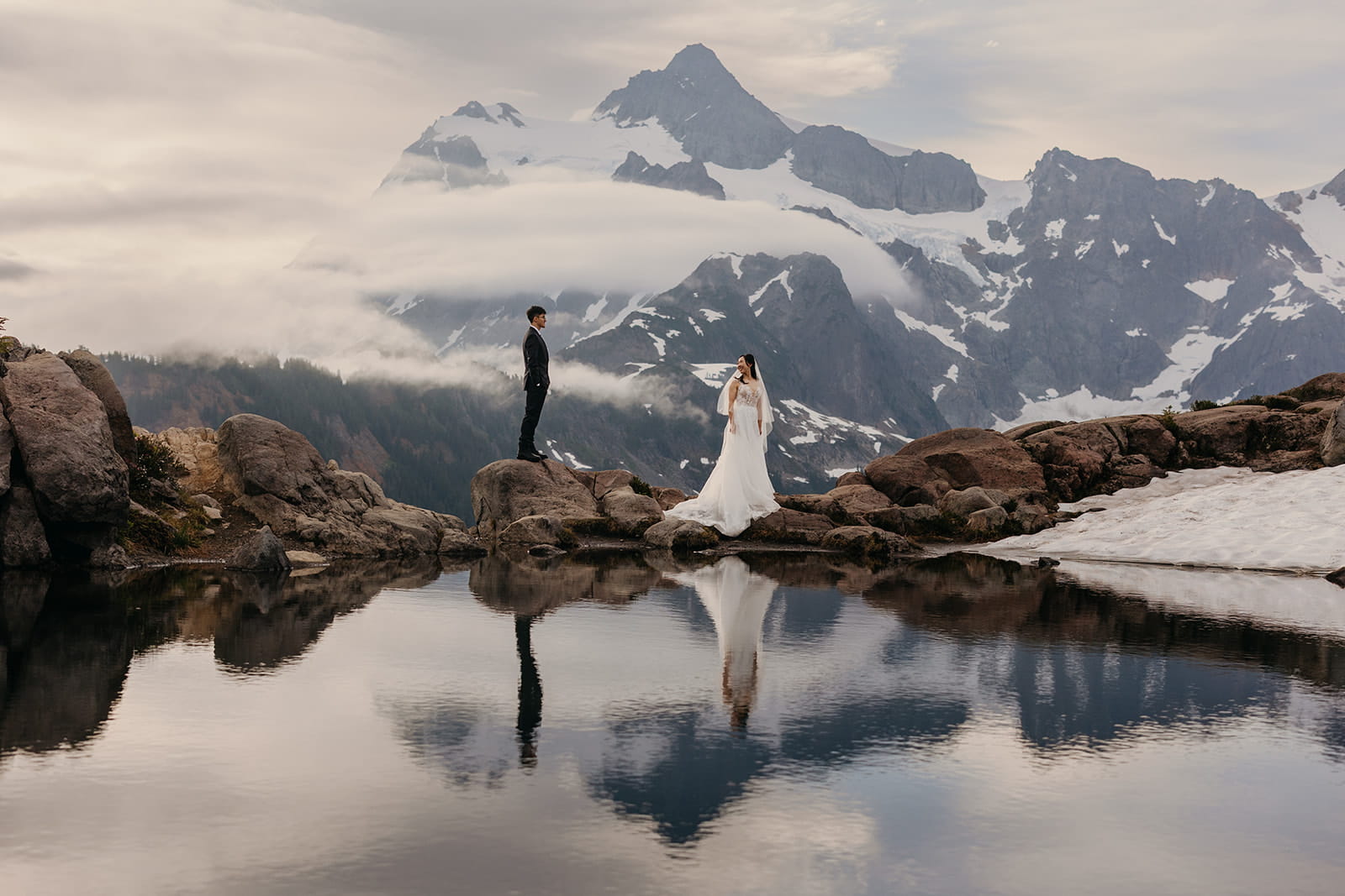 Bride looks back at groom during their mountain elopement wedding photos at Artist Point.