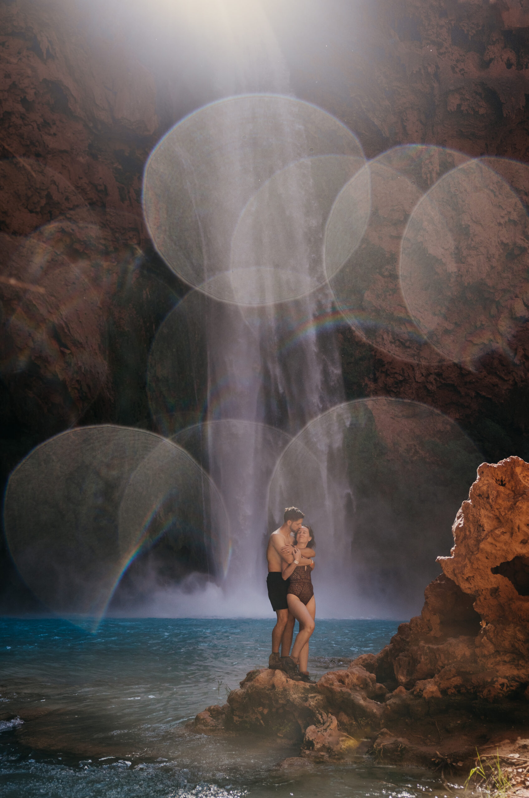 A couple holds each other close as they pose for a photo in front of Mooney falls.