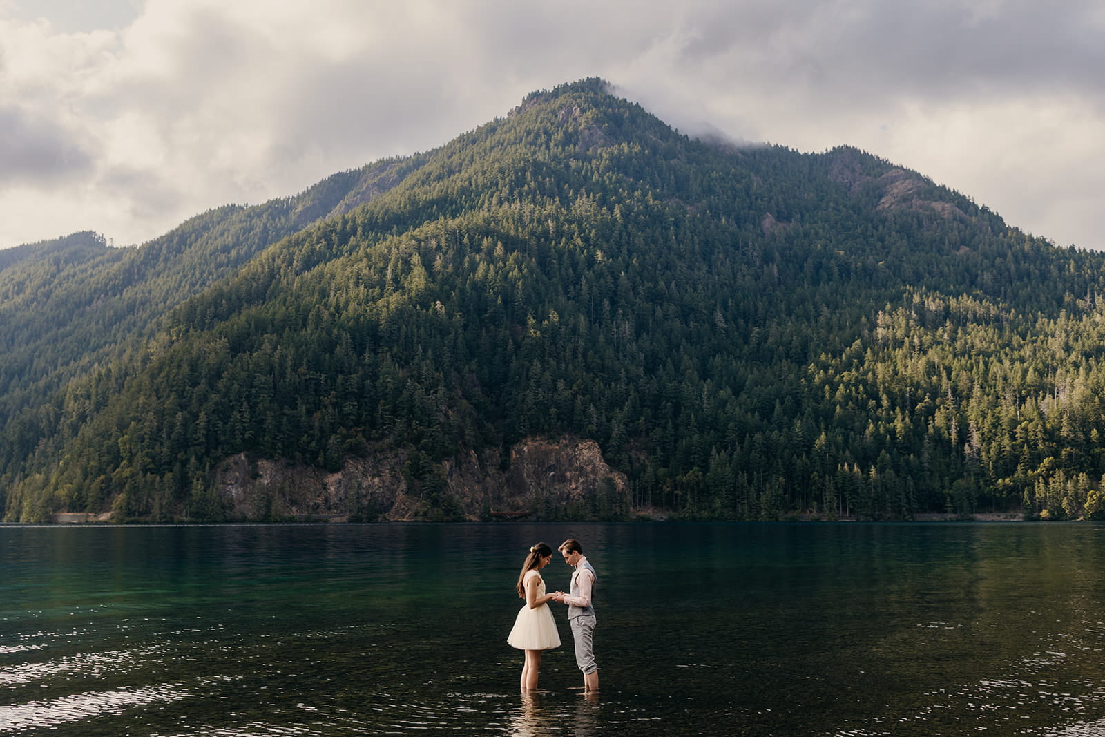 Newlyweds stand in Lake Crescent during their intimate adventure wedding in Port Angeles, Washington.