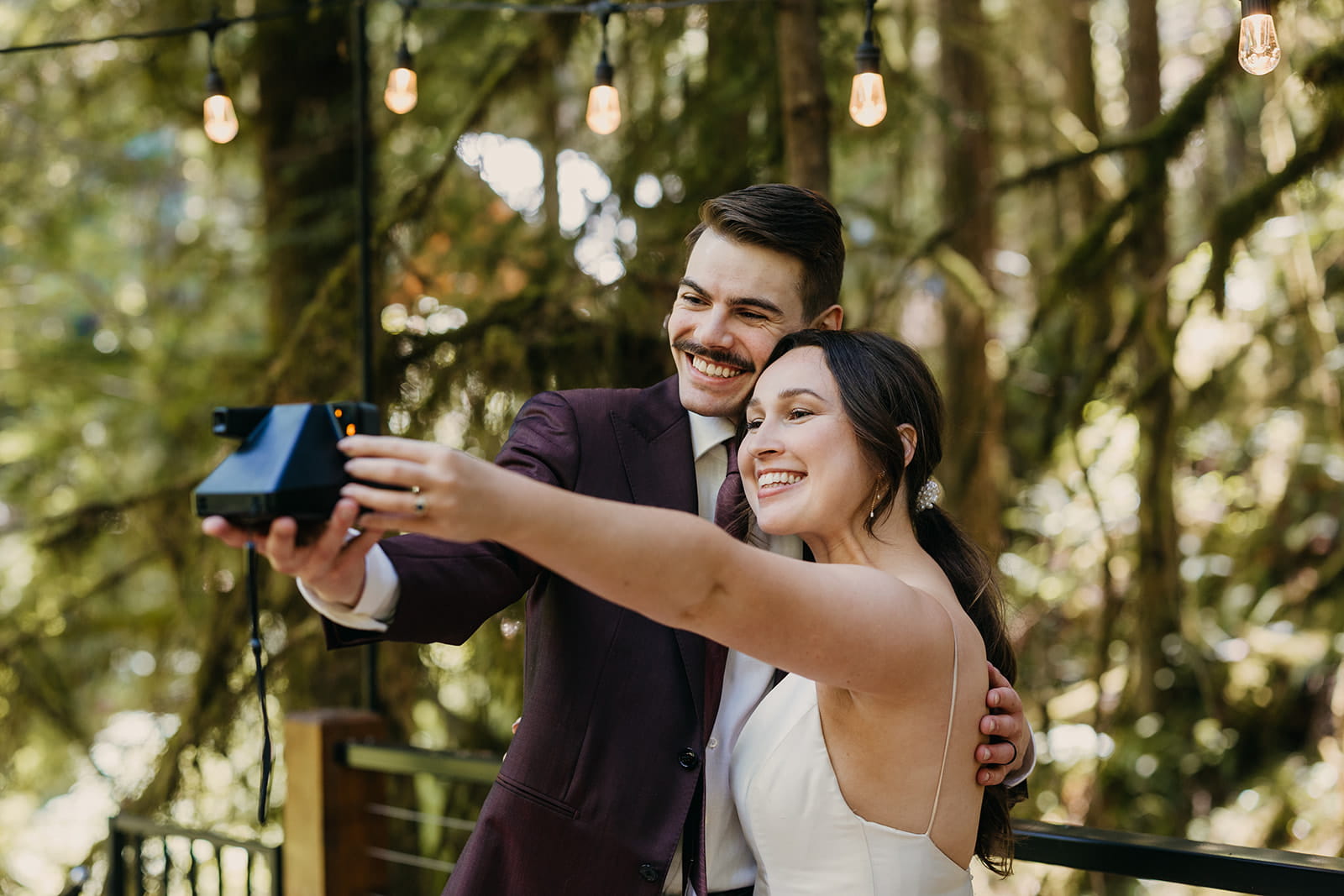Newlyweds take a polaroid selfie during their cabin elopement in Washington.