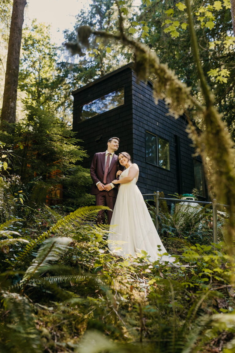 Newlyweds stand on a forest trail in front of the Hygge Hus during their cabin elopement in Mount Baker.