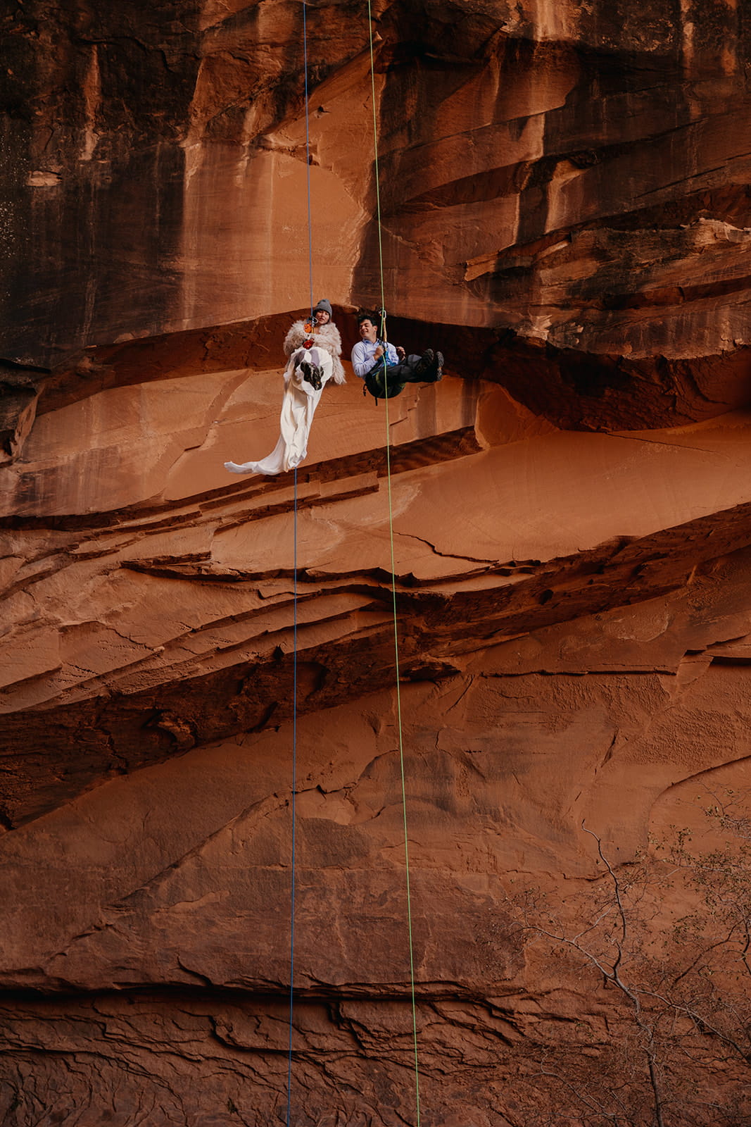 Newlyweds canyoneer in the desert during their winter elopement.