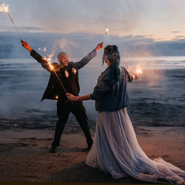 A bride and groom celebrate with sparklers at the end of their wedding day.